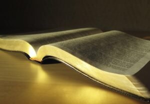 Bible ouverte partiellement éclairée, symbolisant quand Dieu répond mais que la réponse n’est pas toujours reconnue